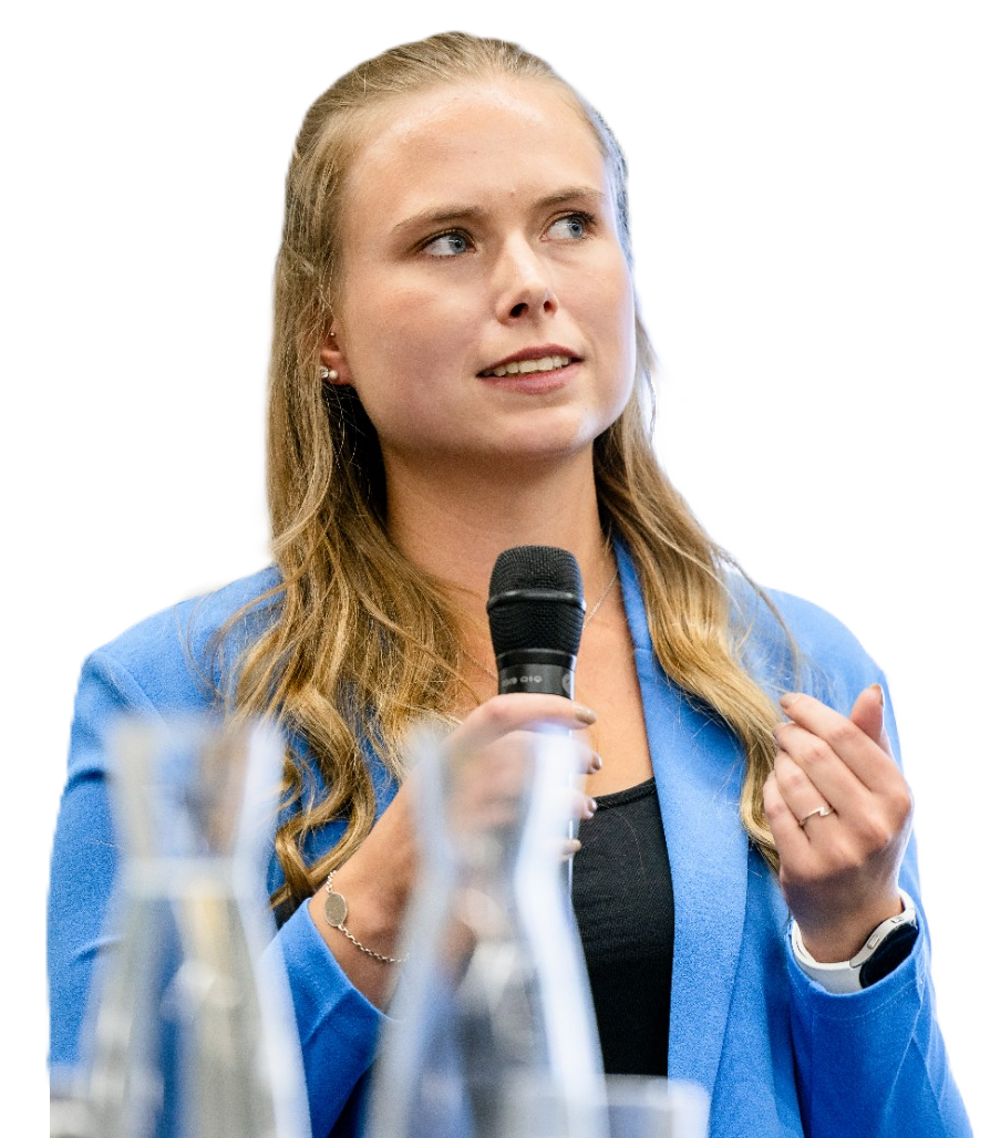 A woman in a blue blazer speaking into a microphone